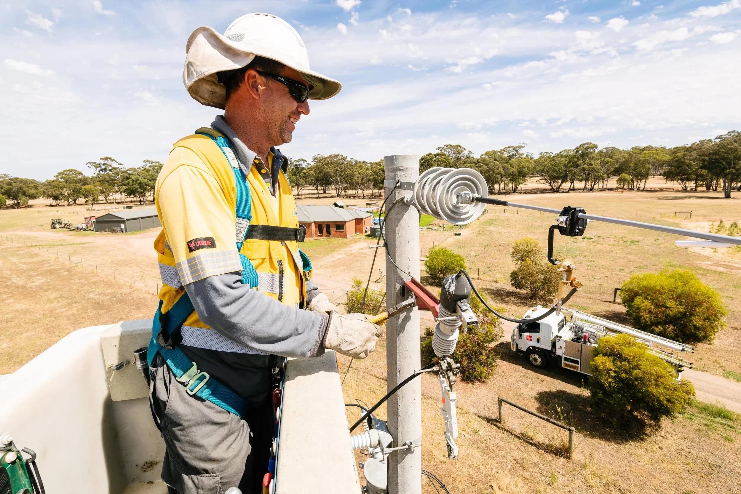 Utility technicians installing and maintaining insulated overhead power conductors on a medium-voltage distribution pole. 复制 Alt